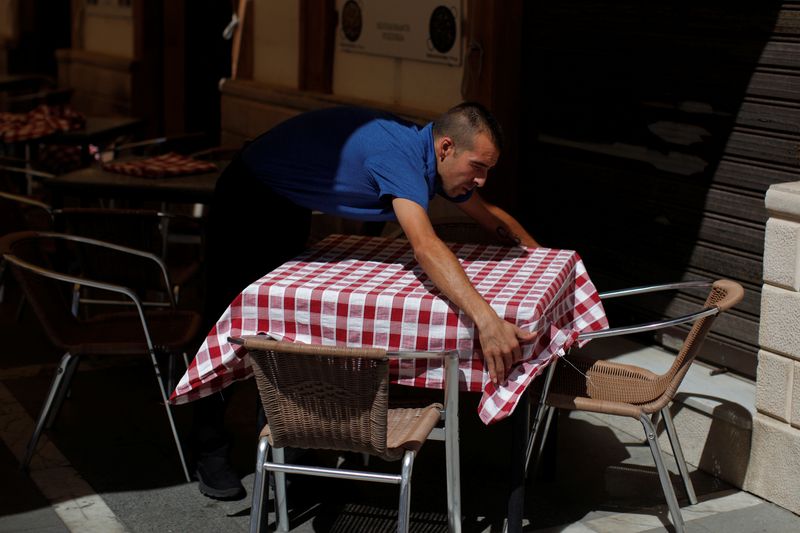 &copy; Reuters. Un camarero arregla un mantel en la terraza de un restaurante en el centro de Ronda, España, 28 de julio de 2016. REUTERS/Jon Nazca