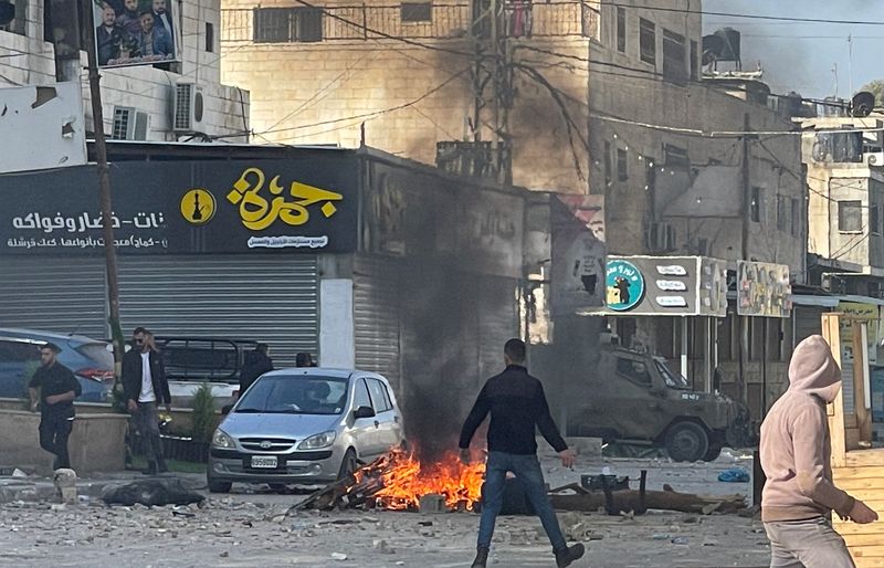 &copy; Reuters. Des hommes palestiniens se rassemblent lors d'affrontements avec les troupes israéliennes dans la ville de Djénine en Cisjordanie occupée par Israël. /Photo prise le 26 janvier 2023/REUTERS/Ali Sawafta