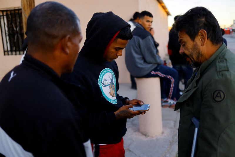 &copy; Reuters. FILE PHOTO: Migrants seeking asylum in the U.S. use their phones to access the U.S. Customs and Border Protection (CBP) CBP ONE application to request an appointment at a land port of entry to the U.S., outside a shelter in Ciudad Juarez, Mexico January 1