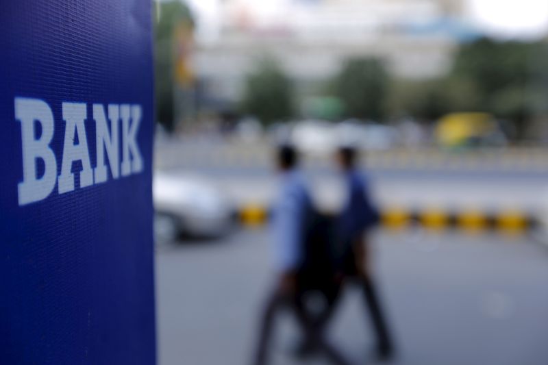 &copy; Reuters. FILE PHOTO: Commuters walk past a bank sign along a road in New Delhi, India, November 25, 2015. REUTERS/Anindito Mukherjee