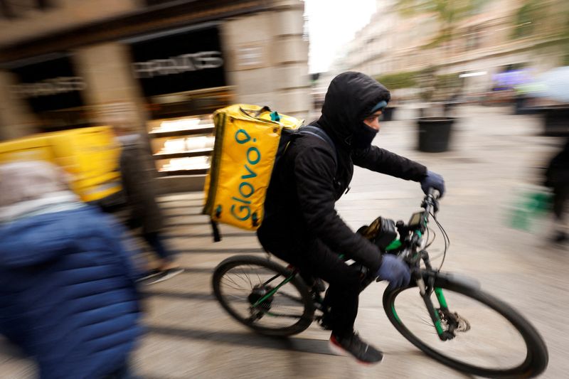 &copy; Reuters. FILE PHOTO: A Glovo delivery rider passes by a pedestrian area in Barcelona, Spain, January 24, 2023. REUTERS/Albert Gea/File Photo