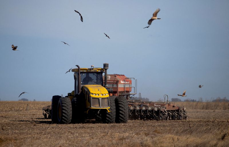 &copy; Reuters. Imagen de archivo. Un trabajador agrícola opera un tractor con una sembradora para sembrar trigo en tierras de cultivo en Comodoro Py, en las afueras de Buenos Aires, Argentina. 21 de junio de 2022. REUTERS/Matias Baglietto