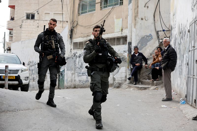 © Reuters. Israeli Border police officers walk outside the house of Palestinian gunman Khaire Alkam in A-Tur in East Jerusalem, after Alkam shot dead at least seven people near a synagogue in Neve Yaacov which lies on occupied land that Israel annexed to Jerusalem after the 1967 Middle East war, January 28, 2023. REUTERS/Ammar Awad