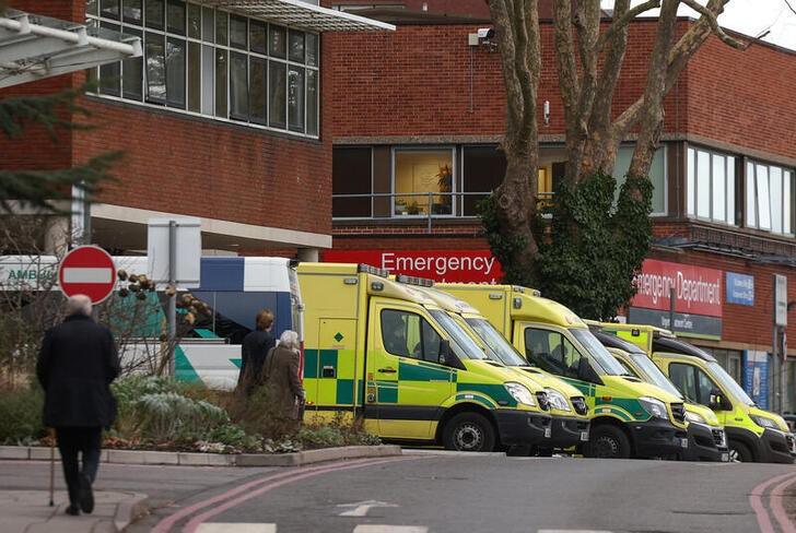 © Reuters. FILE PHOTO: People walk past ambulances outside St George’s University Hospital in London, Britain, January 5, 2023. REUTERS/Henry Nicholls