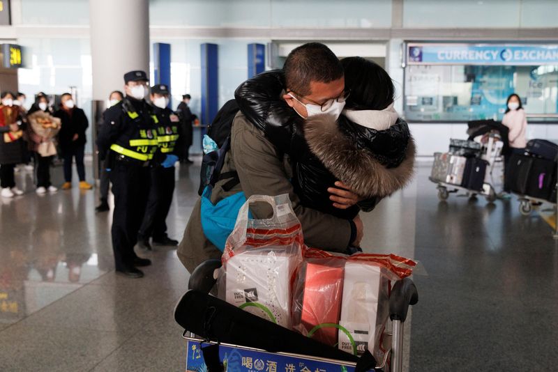 &copy; Reuters. FOTO DE ARCHIVO: Varias personas se abrazan en la puerta de llegadas internacionales del Aeropuerto Internacional de Pekín Capital después de que China levantara el requisito de cuarentena por la enfermedad del coronavirus (COVID-19) para los viajeros e