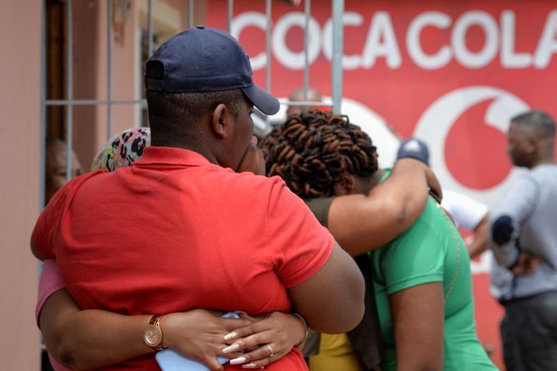 © Reuters. Family members of the victims of a mass shooting at a birthday party that left eight dead, comfort one another at the scene during a visit by a high-level police delegation the day after the shooting in Kwazakhele, Gqeberha, South Africa. January 30, 2023. REUTERS/Deon Ferreira