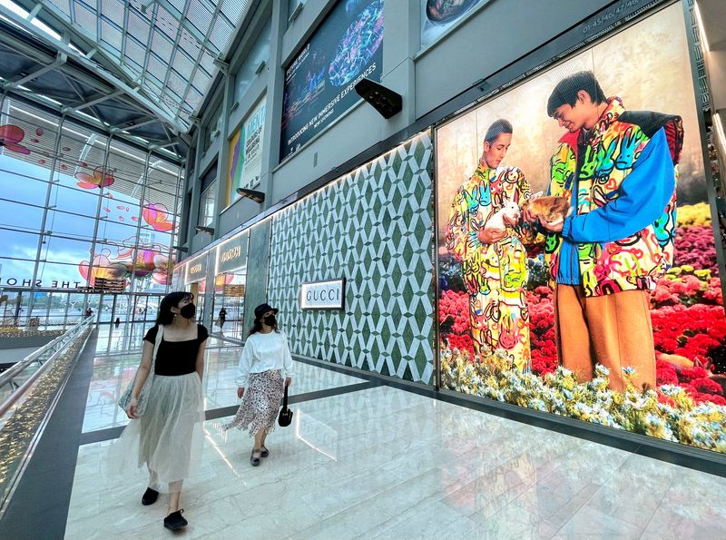 © Reuters. FILE PHOTO: Visitors walk past a Gucci store at Marina Bay Sands in Singapore January 19, 2023. REUTERS/Chen Lin/File Photo