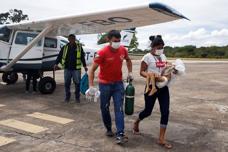 &copy; Reuters. Profissional de saúde carrega oxigênio ao lado de colega com criança yanomami, desnutrida e com pneumonia, que foi retirada de terra indígena de avião para ser atendida em Boa Vista
29/01/2023
REUTERS/Amanda Perobelli