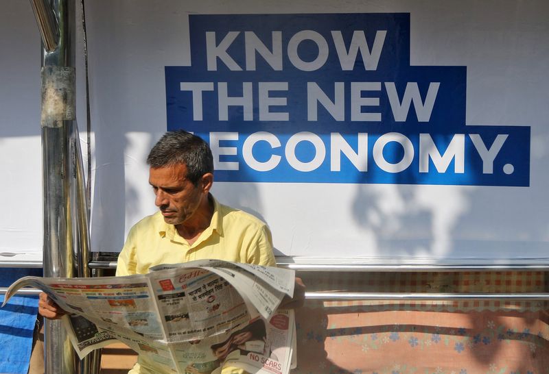 &copy; Reuters. A man reads a newspaper as he waits for public transport at a bus stop in Mumbai, India, January 31, 2017.  REUTERS/Shailesh Andrade/Files