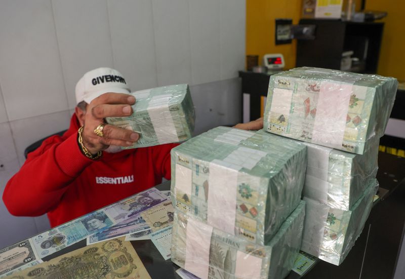 &copy; Reuters. FILE PHOTO: A money exchange vendor holds stacks of Lebanese pound banknotes at a shop in Beirut, Lebanon January 19, 2023. REUTERS/Mohamed Azakir