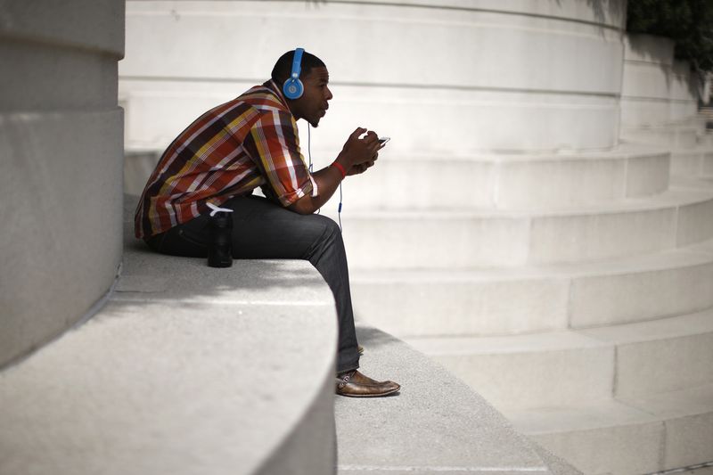 © Reuters. FILE PHOTO: A man with Beats headphones listens to music on an iPhone in Los Angeles, California March 10, 2015. REUTERS/Lucy Nicholson