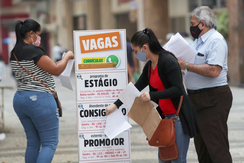 © Reuters. Mulher coloca currículo em caixa ao lado de anúncios de empregos, em São Paulo, Brasil
06/10/2020
REUTERS/Amanda Perobelli