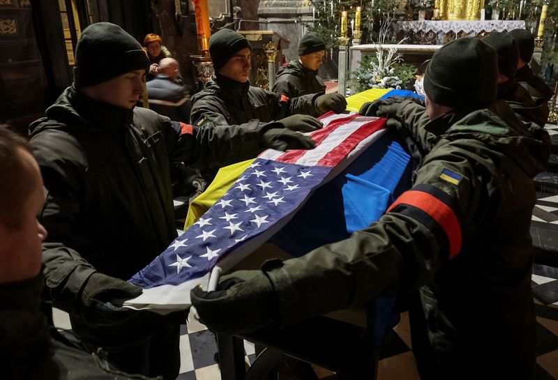 &copy; Reuters. Ukrainian servicemen cover former U.S. Navy SEAL and Ukrainian international legion serviceman Daniel Swift's coffin with American and Ukrainian flags, during a memorial ceremony after he was recently killed in a battle against Russian troops during a mem