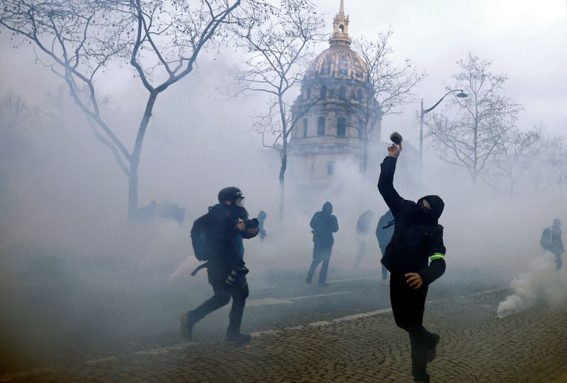 © Reuters. A protester throws a projectile amid tear gas during clashes near the Invalides during a demonstration against French government's pension reform plan in Paris as part of a national strike and protests in France, January 31, 2023.  REUTERS/Gonzalo Fuentes