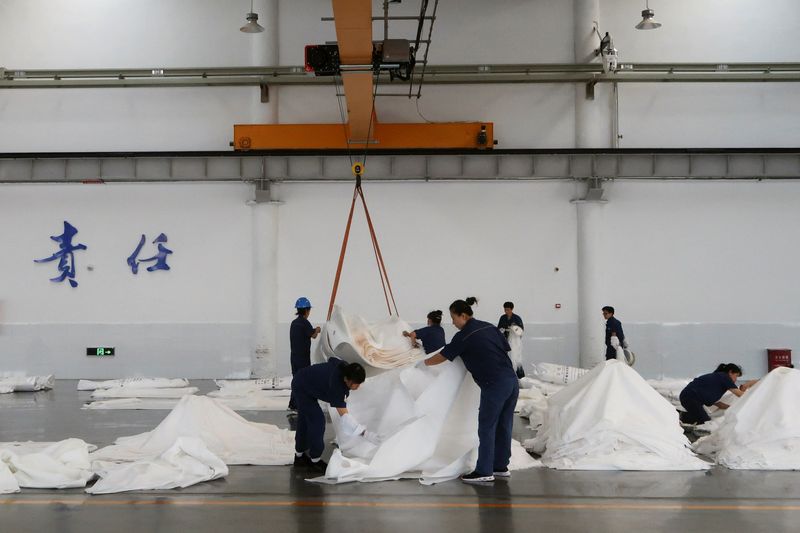 &copy; Reuters. Employees work on the filter cloth production line at Jingjin filter press factory in Dezhou, Shandong province, China August 25, 2022. REUTERS/Siyi Liu/Files