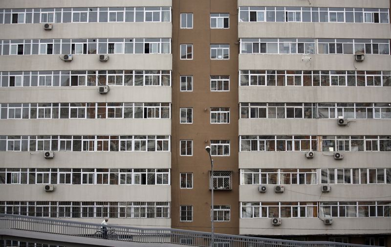 &copy; Reuters. A man riding a bicycle drives past an apartment building in Beijing, March 18, 2015. REUTERS/Kim Kyung-Hoon/Files