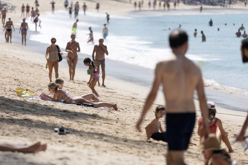 &copy; Reuters. FILE PHOTO: People walk along Kamala beach in Phuket, Thailand, December 27, 2022. REUTERS/Jorge Silva/File Photo