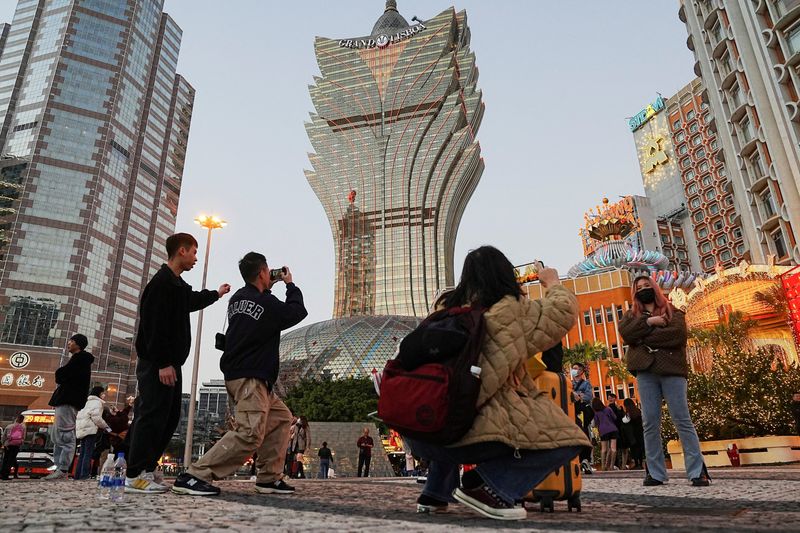 &copy; Reuters. FILE PHOTO: Visitors pose for photos outside the Grand Lisboa casino operated by SJM Holdings during Lunar New Year in Macau, China, January 24, 2023. REUTERS/Lam Yik/File Photo