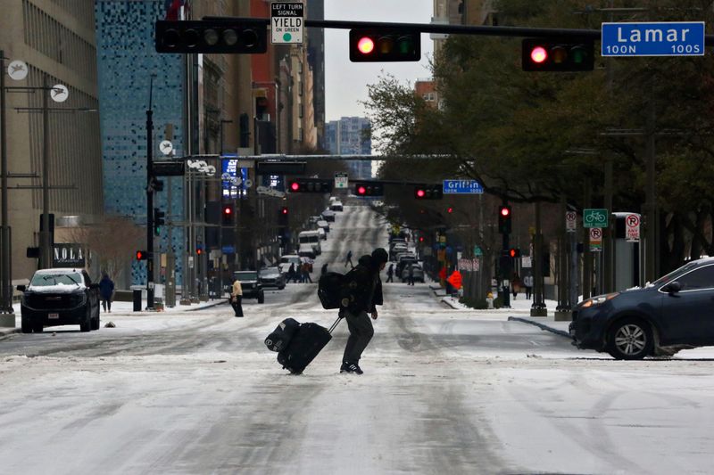 &copy; Reuters. Pedestrians walk across icy roads as a cold weather front moves through Dallas, Texas, U.S., January 31, 2023. REUTERS/Shelby Tauber