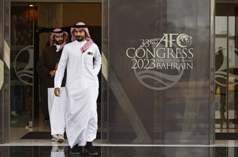 © Reuters. شخصاين يخرجان من مقر انعقاد الجمعية العمومية للاتحاد الآسيوي لكرة القدم 33 في المنامة يوم الأربعاء. تصوير: حمد محمد - رويترز