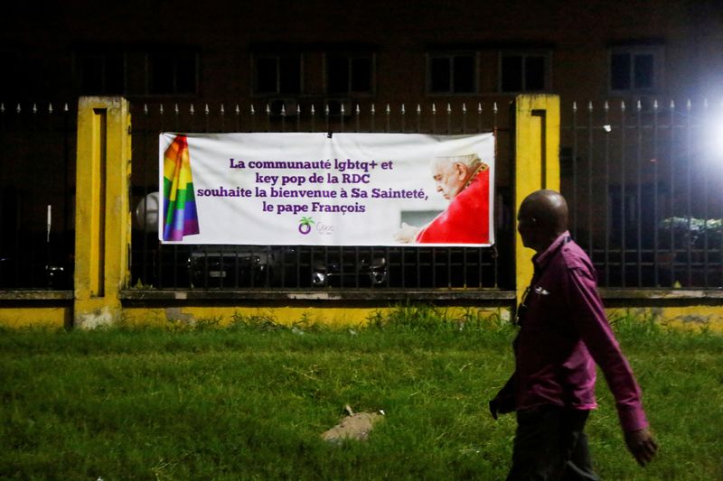 &copy; Reuters. A person walks by a welcome poster by the LGBTQ+ community of RDC for Pope Francis in Kinshasa, Democratic Republic of Congo, February 1, 2023. REUTERS/Luc Gnago