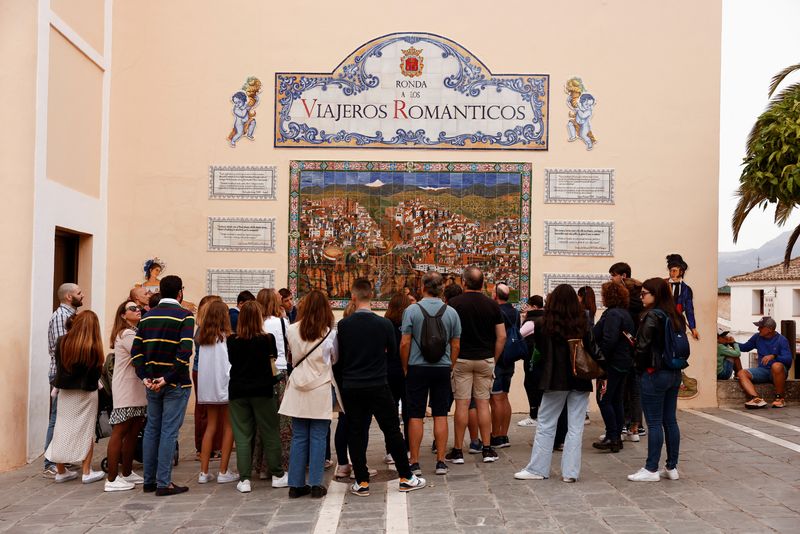 &copy; Reuters. FILE PHOTO: Tourists listen to a guide during a tour in Ronda, Spain October 31, 2022. REUTERS/Jon Nazca
