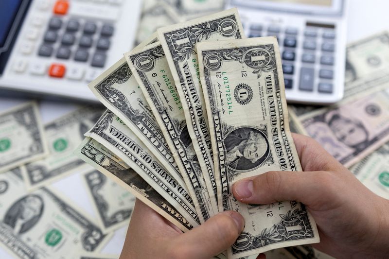 &copy; Reuters. Una donna tiene in mano delle banconote da un dollaro americano in questa illustrazione scattata il 30 maggio 2022. REUTERS/Dado Ruvic/Illustrazione/File Photo