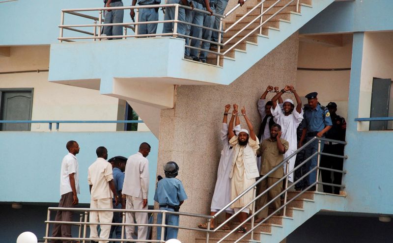 &copy; Reuters. FILE PHOTO: Four Sudanese convicts lift their handcuffs as they are escorted out of the courtroom in the capital Khartoum, June 24, 2009. Four Sudanese men were on Wednesday condemned to hang for killing a U.S. aid official and his driver in Khartoum, and