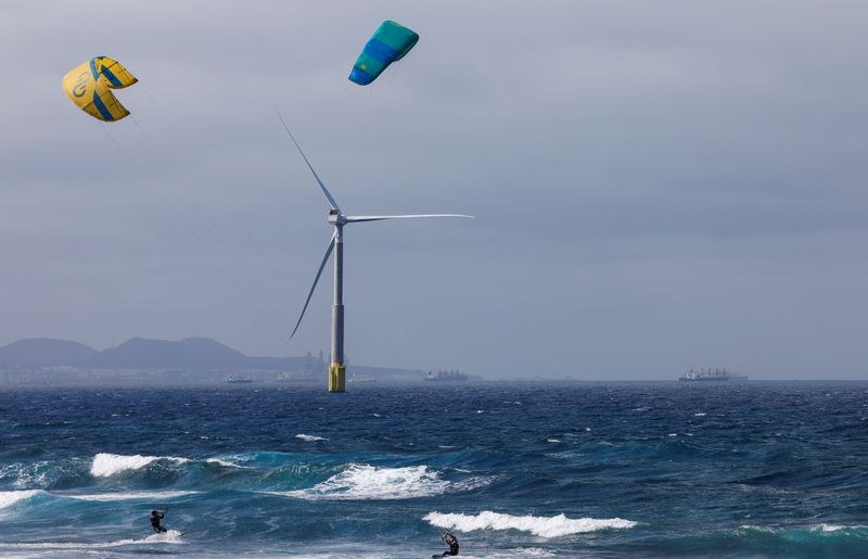 &copy; Reuters. FILE PHOTO: Two sportsmen sail near an offshore wind turbine of the Siemens Gamesa company is seen from the Telde coast on the island of Gran Canaria, Spain, May 2, 2022. REUTERS/Borja Suarez