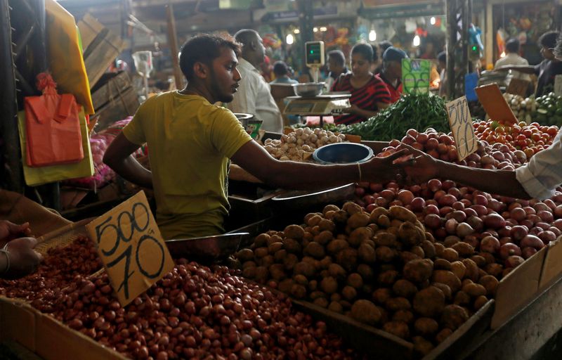 © Reuters. FILE PHOTO: A vendor of a stall exchanges money with a customer at a main market in Colombo, Sri Lanka November 30, 2016. REUTERS/Dinuka Liyanawatte