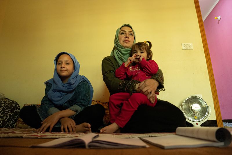 &copy; Reuters. FOTO DE ARCHIVO: La fiscal afgana Roshana Hassas con sus hijas Kawsar y Athar en la habitación que comparte con seis miembros de su familia, mientras espera a la resolución de los últimos trámites para obtener un visado que le permita viajar a España