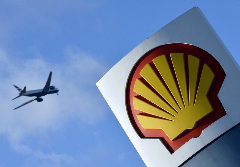 © Reuters. FILE PHOTO: A passenger plane flies over a Shell logo at a petrol station in west London,  January 29, 2015. REUTERS/Toby Melville//File Photo