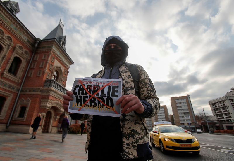 &copy; Reuters. Un participant tient une pancarte dénonçant l'hebdomadaire satirique Charlie Hebdo lors d'une manifestation suite à des remarques de responsables français défendant l'affichage de caricatures du prophète Mahomet, près de l'ambassade de France à Mo