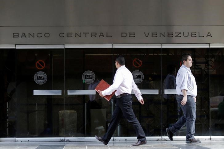 &copy; Reuters. IMAGEN DE ARCHIVO. Personas caminan frente a la entrada del Banco Central de Venezuela, en Caracas. Junio 22, 2017. REUTERS/Marco Bello