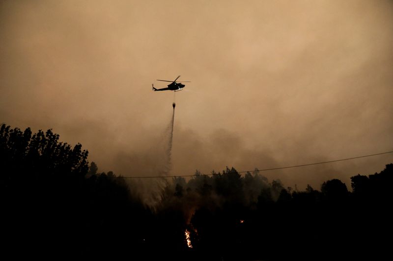 &copy; Reuters. طائرة هليكوبتر تساعد في إخماد حريق هائل في سانتياجو بتشيلي يوم الجمعة. تصوير: جوان جونزاليز - رويترز.