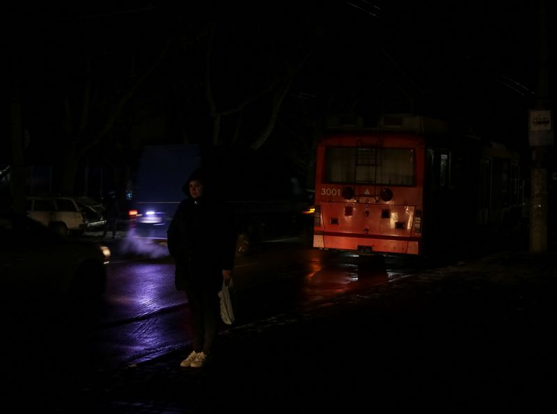 © Reuters. FILE PHOTO: A local resident stands at a transport stop near a stopped trolleybus during a power outage after critical civil infrastructure was hit by Russian missile attacks, as Russia's invasion of Ukraine continues, in Odesa, Ukraine December 5, 2022.  REUTERS/Serhii Smolientsev