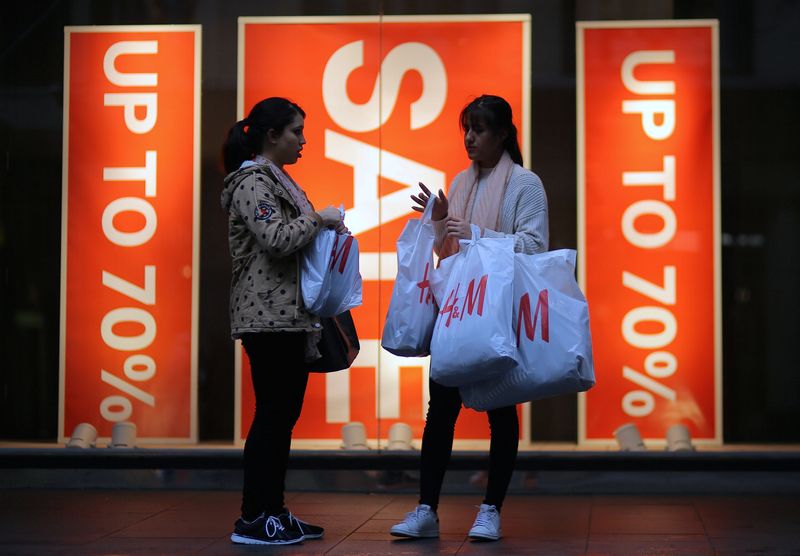 &copy; Reuters. FILE PHOTO: Shoppers carry shopping bags containing purchased goods outside a retail store displaying a sale sign in central Sydney, Australia, June 14, 2017. Picture taken June 14, 2017. REUTERS/Steven Saphore