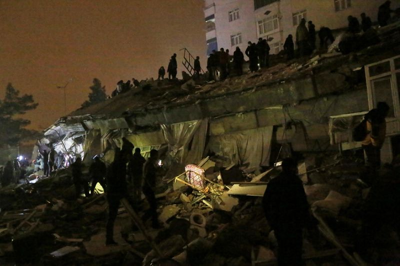 © Reuters. الناس يبحثون عن ناجين وسط أنقاض مبنى منهار  بمنطقة ديار بكر عقب وقوع زلزال في جنوب تركيا يوم الاثنين. تصوير : سيرتاك كايار - رويترز . 