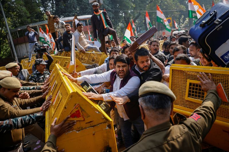 © Reuters. Activists of the youth wing of India's main opposition Congress party try to break a police barricade during a protest against what they say investments by Life Insurance Corporation (LIC) and State Bank of India (SBI) in Adani Group, in New Delhi, India, February 6, 2023. REUTERS/Adnan Abidi