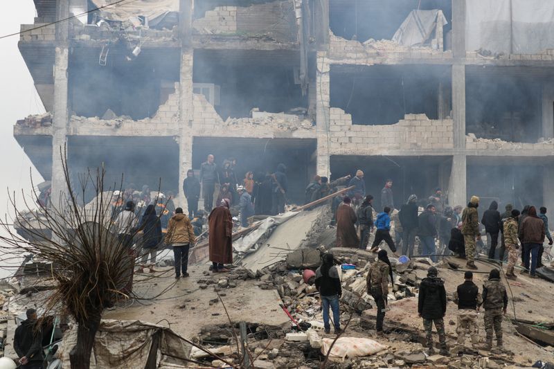 &copy; Reuters. Pessoas e equipes de resgate buscam por pessoas em esombros após terremoto na cidade síria de Jandaris
06/02/2023 REUTERS/Khalil Ashawi