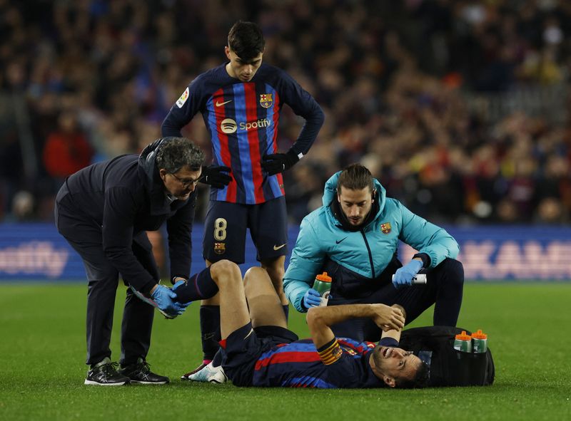 © Reuters. لاعب وسط برشلونة سيرجيو بوسكيتس يتلقى العلاج الطبي بعد إصابته خلال مباراة فريقه أمام إشبيلية في برشلونة يوم الأحد. تصوير: ألبرت خيا - رويترز