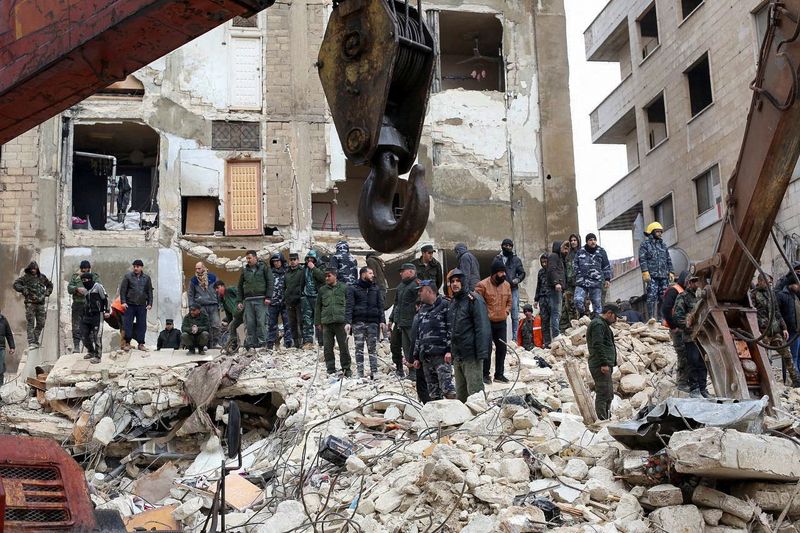 &copy; Reuters. رجال الإنقاذ في حماة السورية يستخدمون معدات ثقيلة في البخث عن ناجين تحت أنقاض مبان تهدمت نتيجة الزلزال الذي ضرب المنطقة يوم الاثنين. تصوير: 