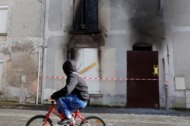 &copy; Reuters. Jovem passa de bicicleta em frente à casa incendiada onde mãe e seus sete filhos morreram em Aisne, na França
06/02/2023 REUTERS/Pascal Rossignol