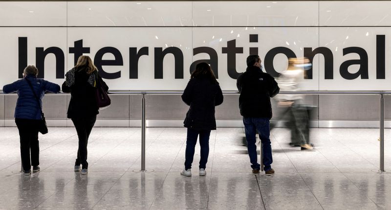 © Reuters. FILE PHOTO: People are seen waiting at the arrivals area of terminal 5 at Heathrow International airport following the lifting of restrictions on the entry of non-U.S. citizens imposed to help curb the spread of the coronavirus disease (COVID-19), in London, Britain November 8, 2021. REUTERS/Carlos Barria/File Photo