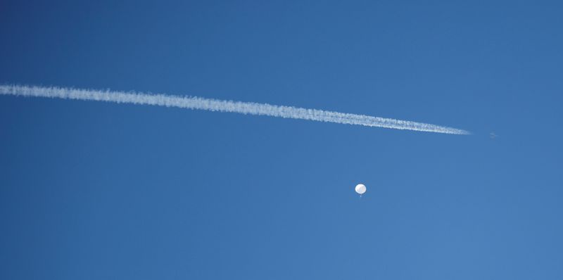 © Reuters. A jet flies by a suspected Chinese spy balloon as it floats off the coast in Surfside Beach, South Carolina, U.S. February 4, 2023.  REUTERS/Randall Hill