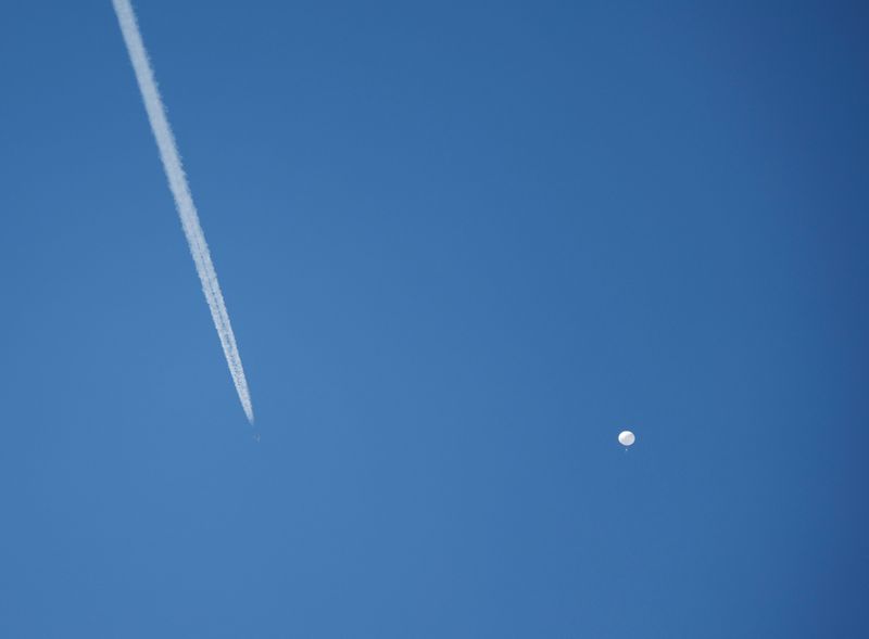 © Reuters. A jet flies by a suspected Chinese spy balloon as it floats off the coast in Surfside Beach, South Carolina, U.S. February 4, 2023.  REUTERS/Randall Hill