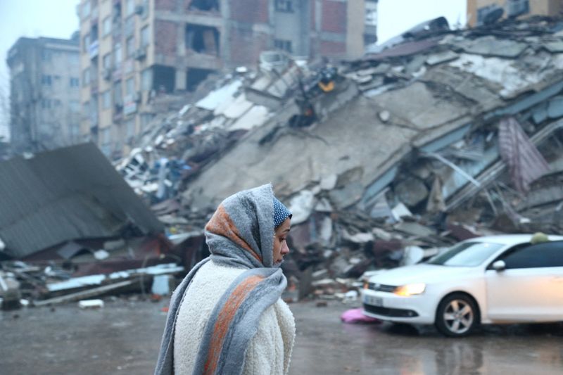 © Reuters. A woman stands near a collapsed building after an earthquake in Kahramanmaras, Turkey February 6, 2023. REUTERS/Cagla Gurdogan     