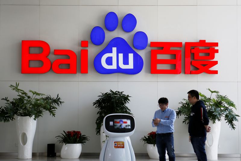 &copy; Reuters. FILE PHOTO: Men interact with a Baidu AI robot near the company logo at its headquarters in Beijing, China April 23, 2021. REUTERS/Florence Lo