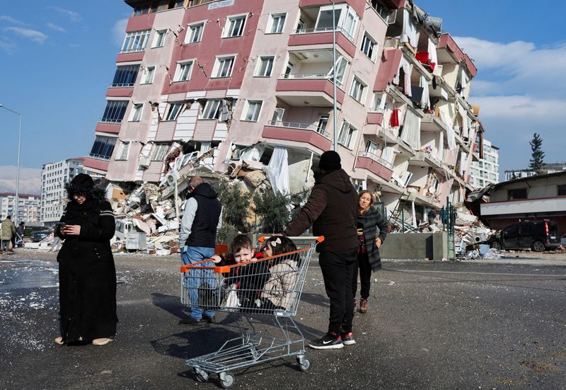 &copy; Reuters. Criança em carrinho de compras perto de prédio destruído por terremoto em Hatay, na Turquia
07/02/2023 REUTERS/Umit Bektas