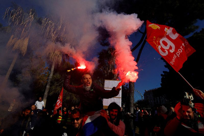 © Reuters. Protesters hold CGT labour union flags and flares during a demonstration against French government's pension reform plan in Nice as part of the third day of national strike and protests in France, February 7, 2023.  REUTERS/Eric Gaillard